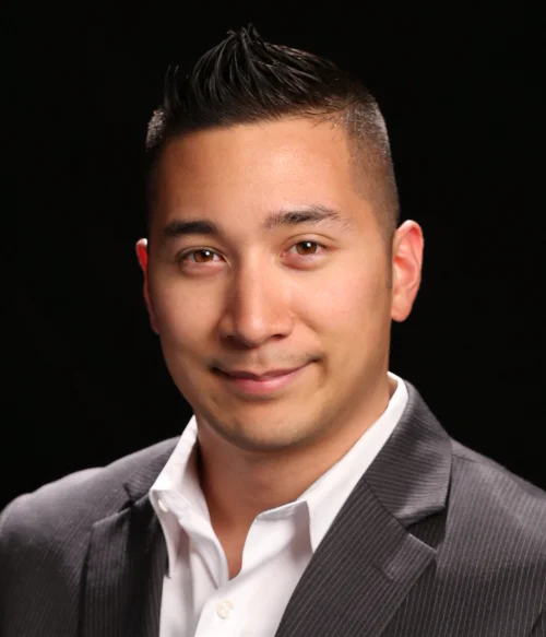 Portrait of Brandon Wong, founder of Smart Forge Media, in a gray blazer and white open-collar shirt